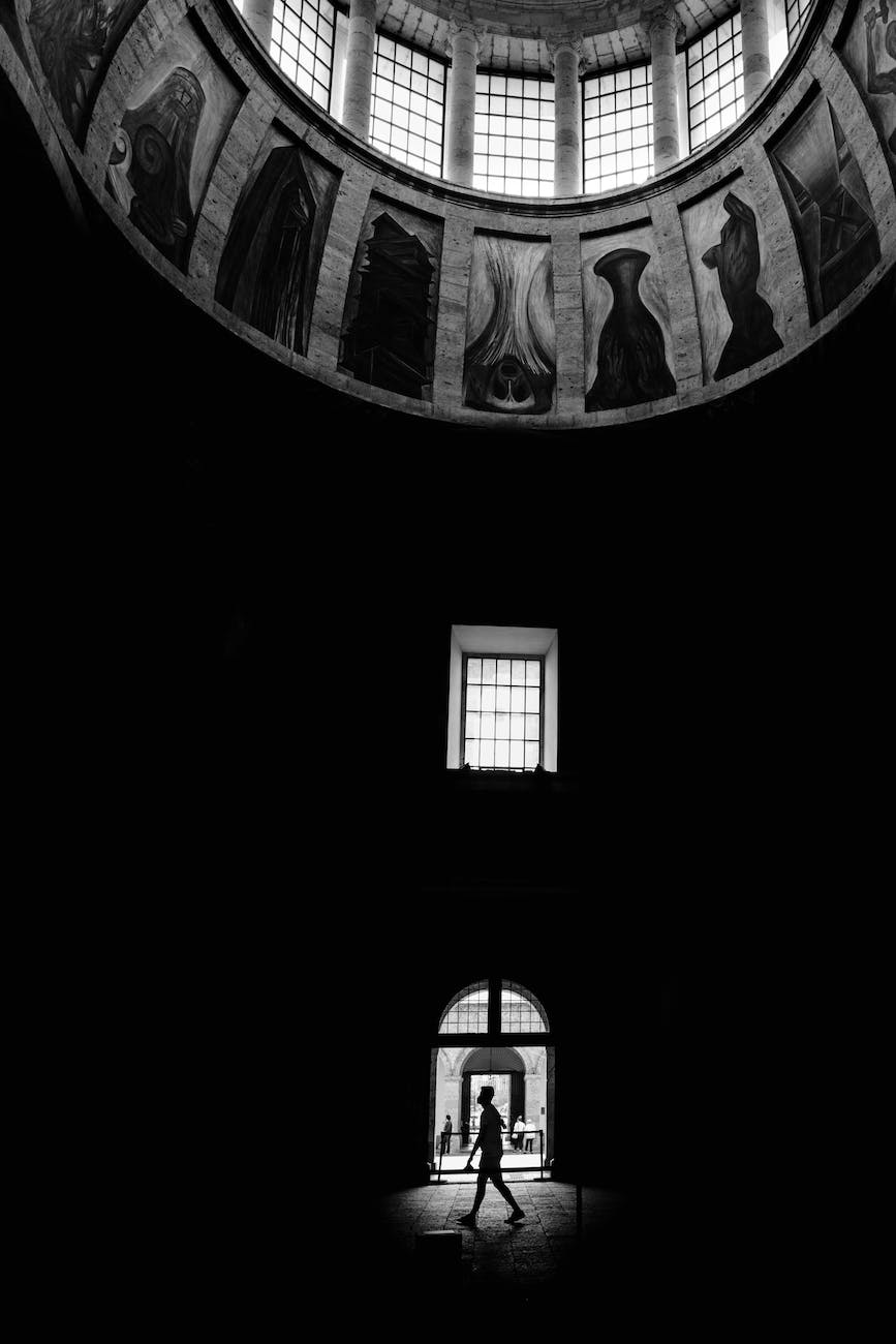 a silhouette of a person walking by the entrance of the museum cabanas